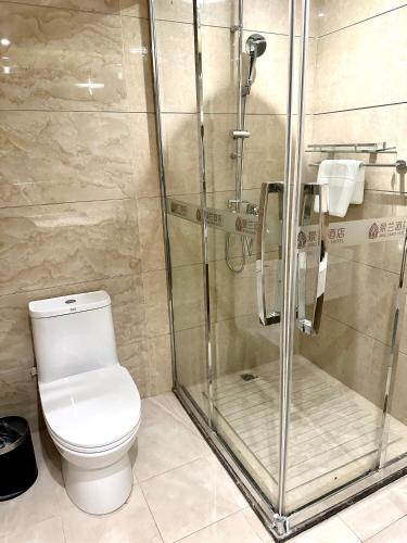 a bathroom with a toilet and a glass shower at 慧兰酒店bodhi hotel in Ban Botèn