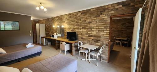 a living room with a brick wall at Magdala Motor Lodge & Lakeside Restaurant in Stawell