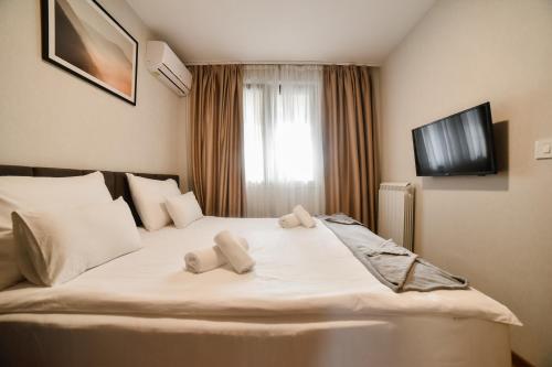 a bedroom with a bed with two towels on it at Kraljev trg - lux apartman in Zlatibor