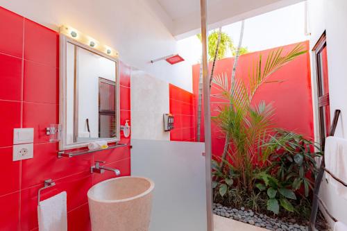 a red bathroom with a sink and a mirror at Bali Ginger Suites & Villa in Seminyak
