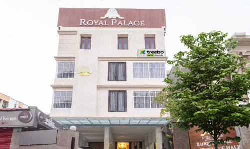 a tall white building with a sign on it at Treebo Trend Royal Palace, Zoo Road in Dispur