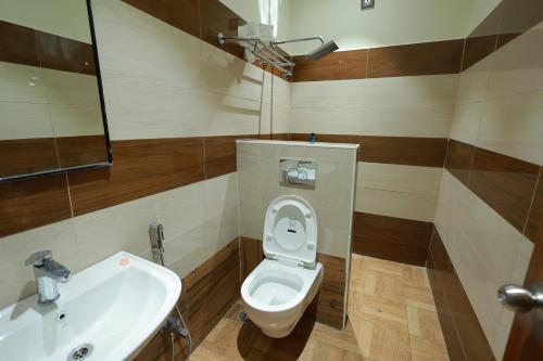 a bathroom with a toilet and a sink at HOTEL SVM GRAND RAMANTHAPUR in Hyderabad