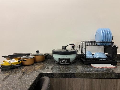 a kitchen counter with pots and pans on a counter top at QUINCE HOME GRAND ION DELEMEN GENTING HIGHLANDs in Genting Highlands