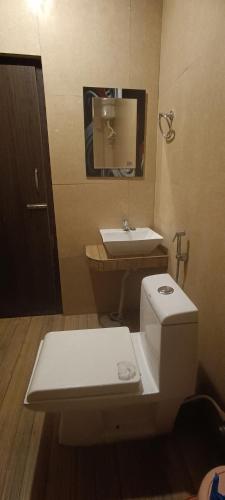 a bathroom with a toilet and a sink at Joye Grand Hotel in Havelock Island