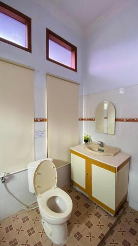 a bathroom with a toilet and a sink at Omah Najwa by Sampai Coliving in Kejayan