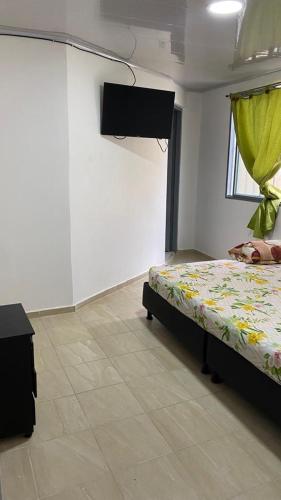 a bedroom with a bed and a television in a room at Restaurante y hospedaje La fonda in Santa Rosa de Cabal