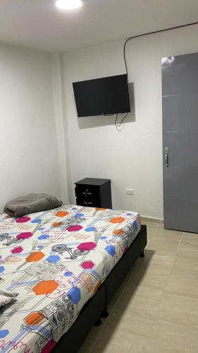 a bedroom with a bed and a flat screen tv at Restaurante y hospedaje La fonda in Santa Rosa de Cabal