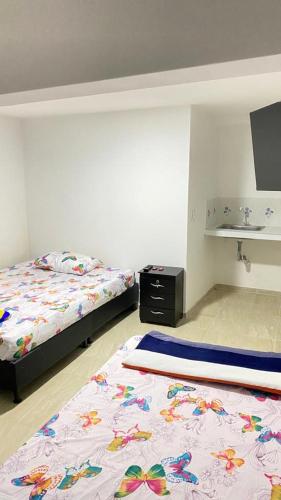 1 dormitorio con 2 camas y lavamanos. en Restaurante y hospedaje La fonda en Santa Rosa de Cabal
