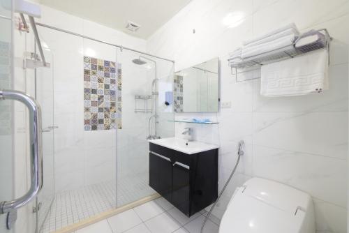 a bathroom with a shower and a toilet and a sink at Sunshine B&B in Hualien City