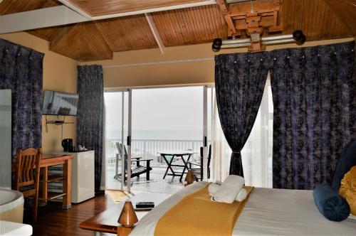 a bedroom with a bed with a view of the ocean at Point Village Guest House in Mossel Bay