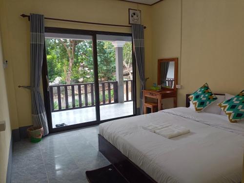 Schlafzimmer mit einem Bett und Blick auf einen Balkon in der Unterkunft Khamphan Guesthouse in Nongkhiaw