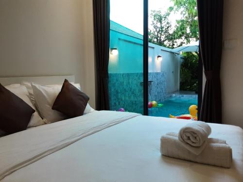 Schlafzimmer mit einem Bett und Poolblick in der Unterkunft Paul Pool Villa Pattaya in Bang Sare