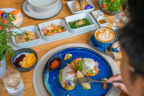 a table with a blue plate of food on it at Proud Phu Fah Muang Chiang Mai in Chiang Mai