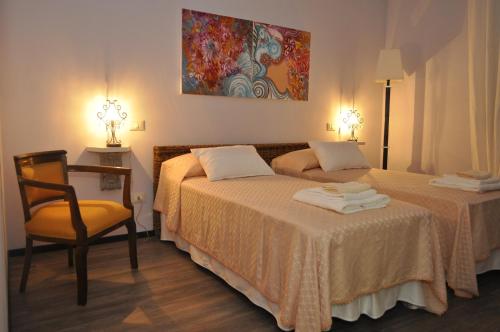 a hotel room with two beds and a chair at B&B Acquamarina in Marina di Massa