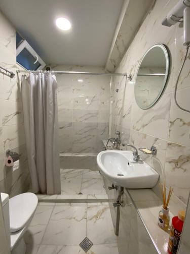 uma casa de banho com um lavatório, um WC e um espelho. em Guest House GML-1 em Tbilisi