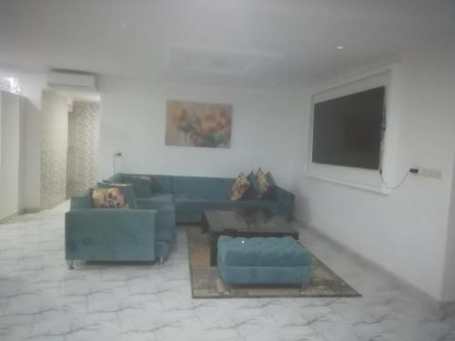 ein Wohnzimmer mit 2 blauen Sofas und einem Flachbild-TV in der Unterkunft R&r in Skhirat