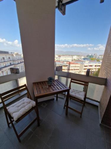 a table and chairs on a balcony with a view at Heart of the City - 75sqm Suite in Skopje