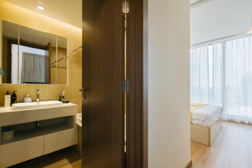 een badkamer met een wastafel, een spiegel en een bed bij Royal Serviced apartment Vinhomes Metropolis in Hanoi
