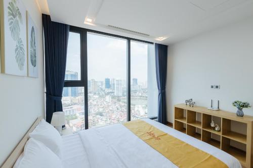 een slaapkamer met een bed en een groot raam bij Royal Serviced apartment Vinhomes Metropolis in Hanoi