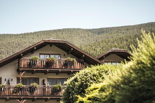 a house with potted plants on a balcony at Hotel Angelo Engel in Ortisei
