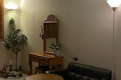 a living room with a mirror and a table at Hanra guesthouse in Jeju