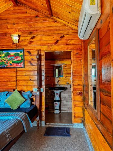 a bedroom with a sink in a log cabin at O3 Beach Resort in Palolem