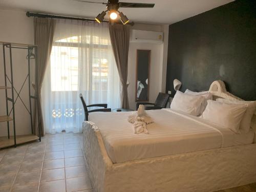 a bedroom with a large bed with a stuffed animal on it at Big Boys' Bed & Burger - Patong Beach in Patong Beach