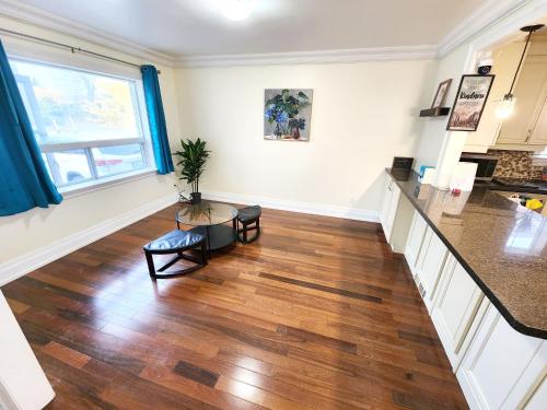 a kitchen and living room with wood floors and a table at Toronto Uptown 3 - Bus to Downtown in Toronto