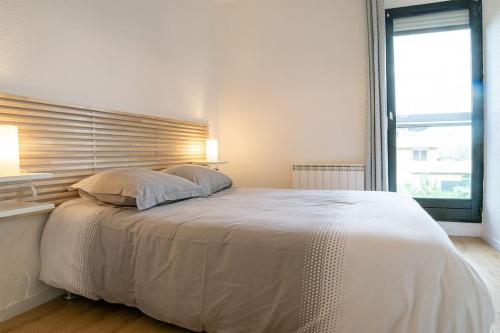 een slaapkamer met een groot wit bed en een raam bij Ville & Nature, Belle Vue avec Piscine in Chamalières