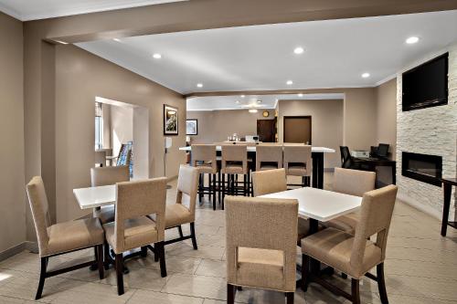 a dining room with tables and chairs and a kitchen at Comfort Inn Lacey - Olympia in Lacey