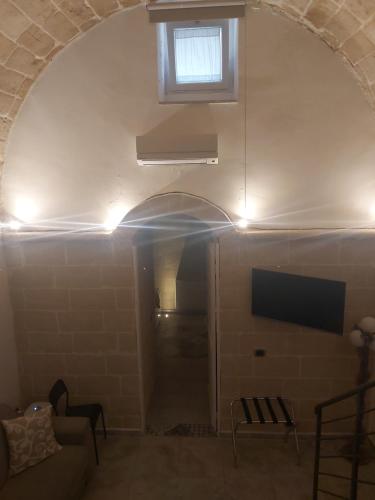 a room with an archway with a television and a couch at Dimora Margherita in Matera