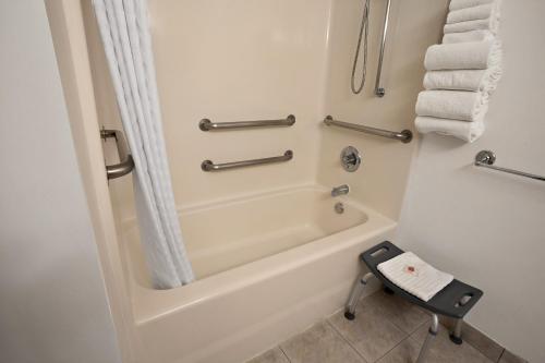 a bathroom with a tub and a shower with towels at Comfort Inn Lacey - Olympia in Lacey