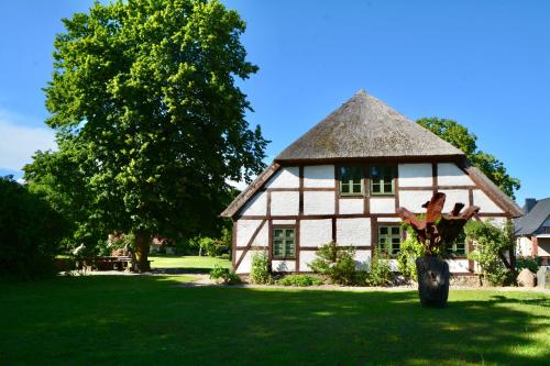 an old house with a thatched roof in a yard at Alte Ausspanne in Walkendorf