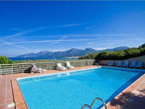 a swimming pool with a view of the mountains at Appartement dans la residence calme in Saint-Florent