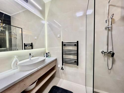 een witte badkamer met een wastafel en een douche bij Apartment Aleksandr first line sea view in Igalo