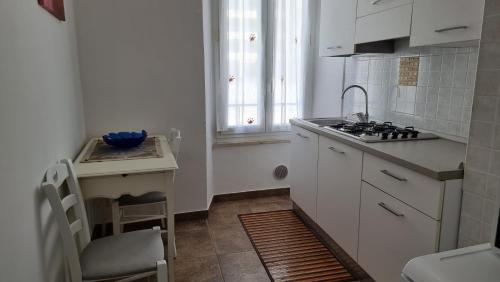 a kitchen with white cabinets and a sink and a window at Antico Borgo Piceno in Ascoli Piceno