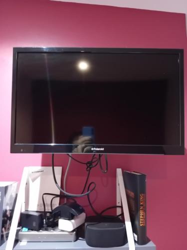 a flat screen tv sitting on top of a shelf at Anexe in Lempdes