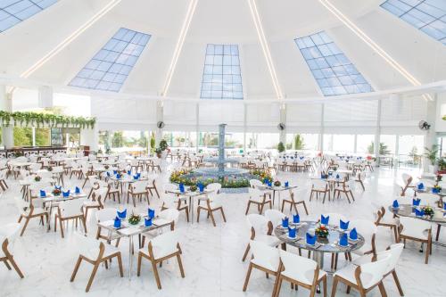 um salão de banquetes com mesas e cadeiras e uma fonte em Carmelina Beach Resort Ho Tram em Ho Tram