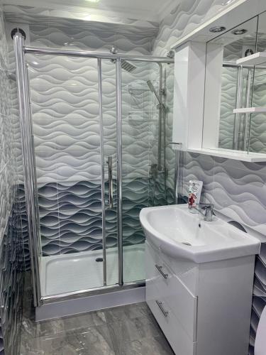 een badkamer met een douche en een wastafel bij Comfortable apartments!!! View!!! in Chişinău