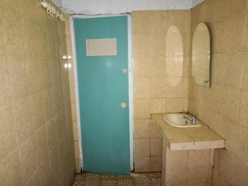 a bathroom with a blue door and a sink at OYO 93241 Hotel Puri Azzura Danau Ranau in Jepara