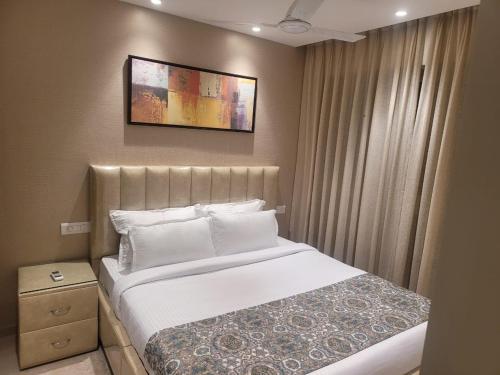 a bedroom with a bed and a picture on the wall at Sapphire Asta- Regent Hills in Mumbai