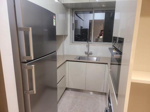 a kitchen with a stainless steel refrigerator and a sink at Sapphire Asta- Regent Hills in Mumbai