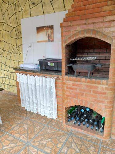 a brick oven with a bunch of wine bottles at Aconchego da Vovó in Araruama