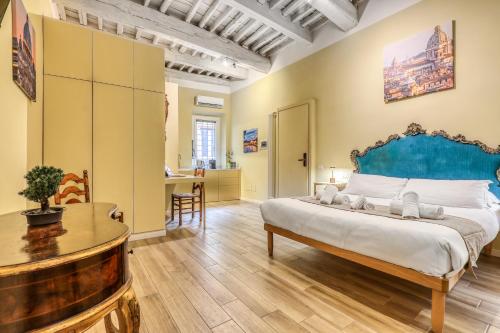 een slaapkamer met een groot bed en een tafel bij Domus Orbitelli in Rome
