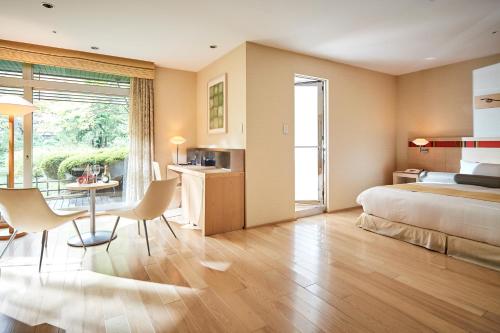 a bedroom with a bed and a table and chairs at Sapporo Grand Hotel in Sapporo