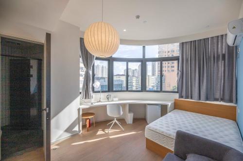 a bedroom with a bed and a desk and a sink at Tulu Apartment Shanghai Xuhui in Shanghai