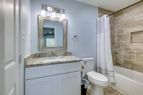 y baño con lavabo, aseo y espejo. en Vacation Home Lake Livingston!, en Onalaska