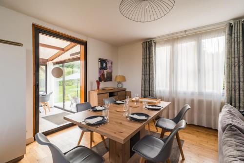 une salle à manger avec une table et des chaises en bois dans l'établissement Maison Poulpry - Grande maison pour 9 à 600m de la plage, à Penvénan