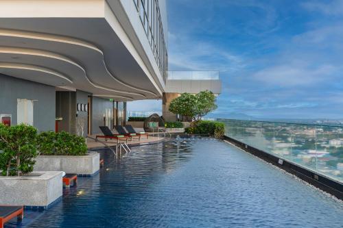 uma piscina de hotel com vista para a cidade em Holiday Inn & Suites Rayong City Centre, an IHG Hotel em Rayong