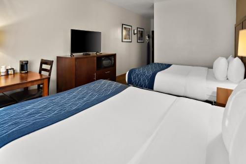 a hotel room with two beds and a desk and a tv at Comfort Inn Lacey - Olympia in Lacey
